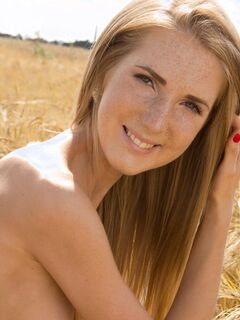 Тощая рыжая девушка голая в поле - фото