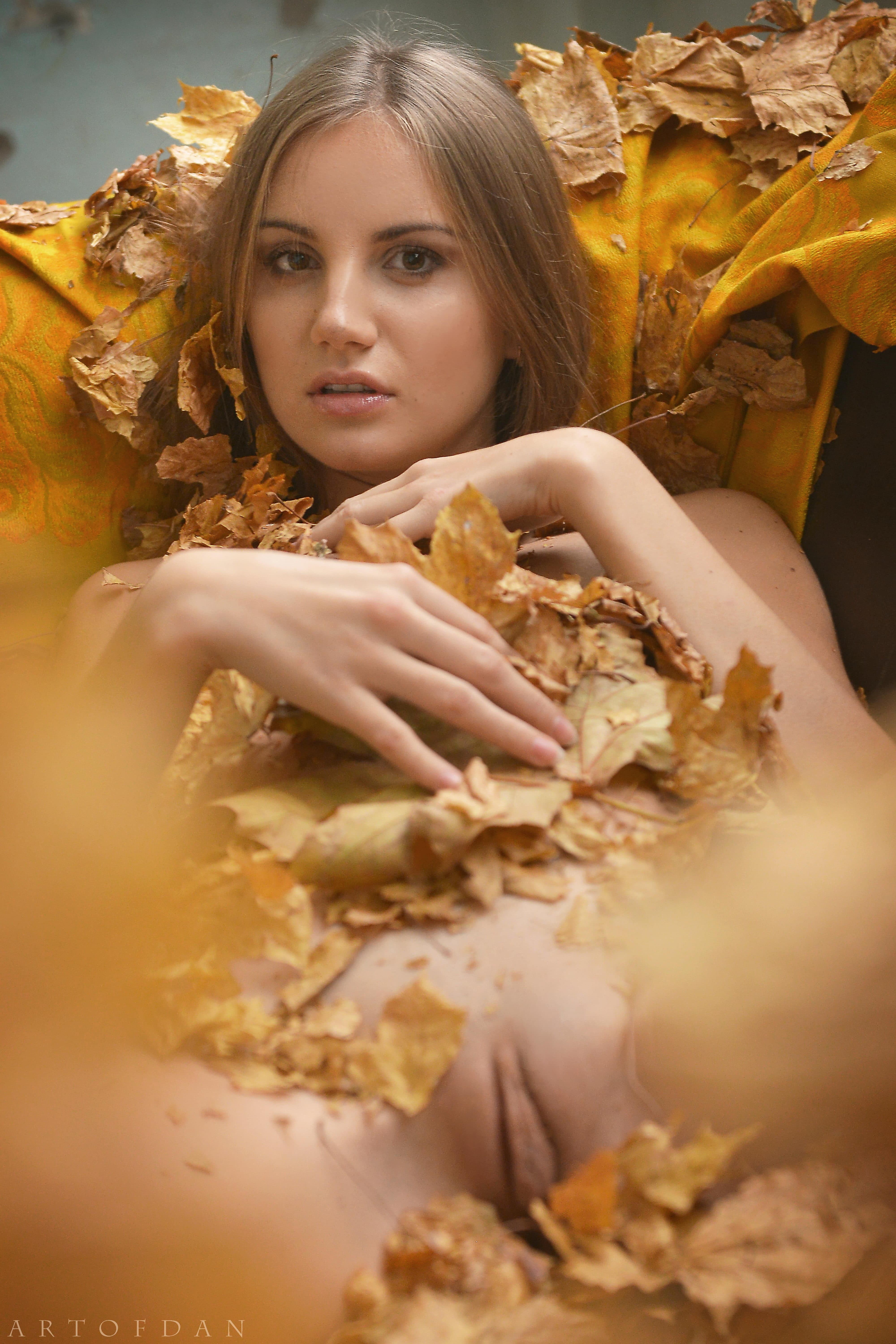 Голая девушка в осенней листве - фото