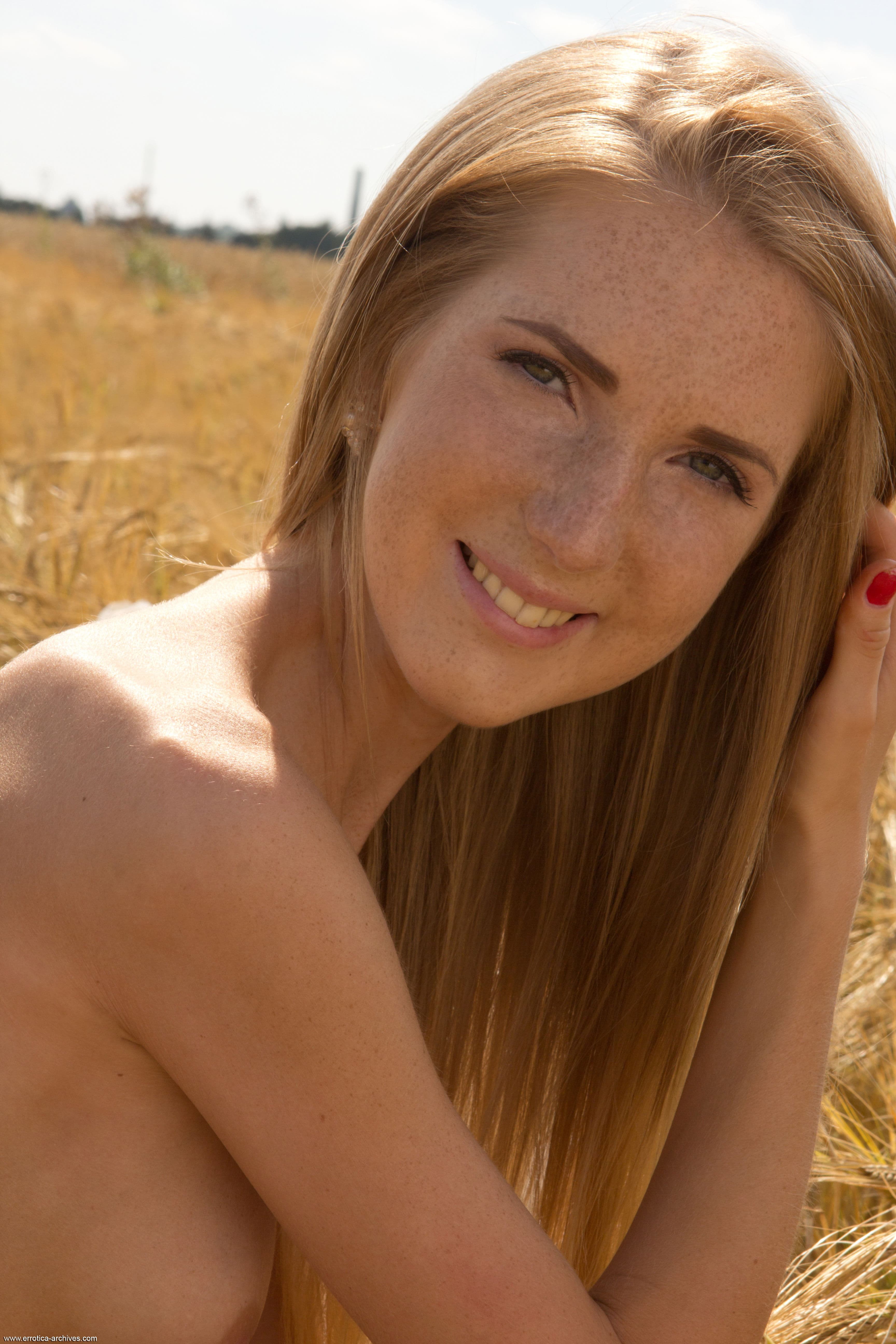 Тощая рыжая девушка голая в поле - фото