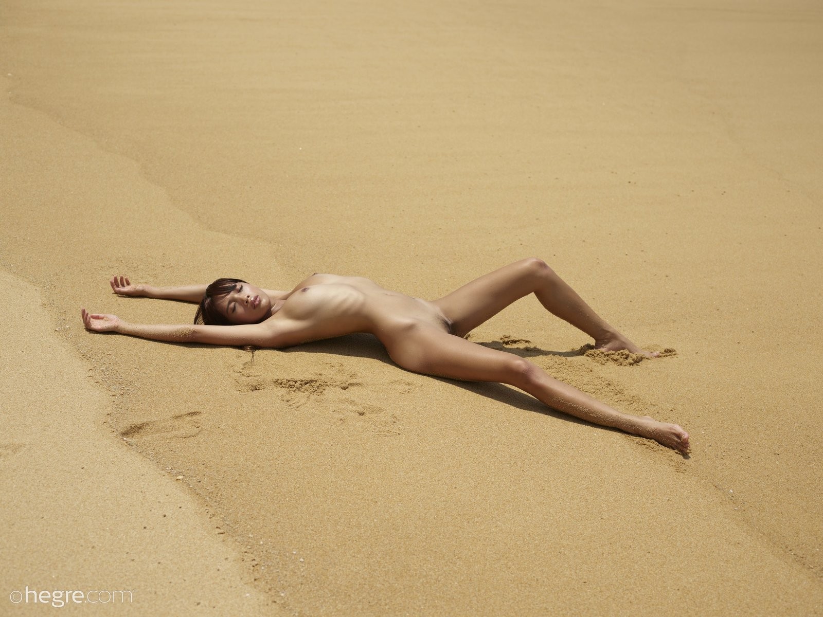 Миниатюрная смуглая азиатка на пляже - фото